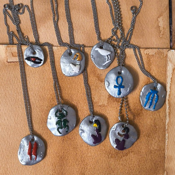 Set of necklaces with various pendant designs on a brown surface