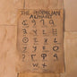 Sheet of paper with Phoenician alphabet text on a textured surface
