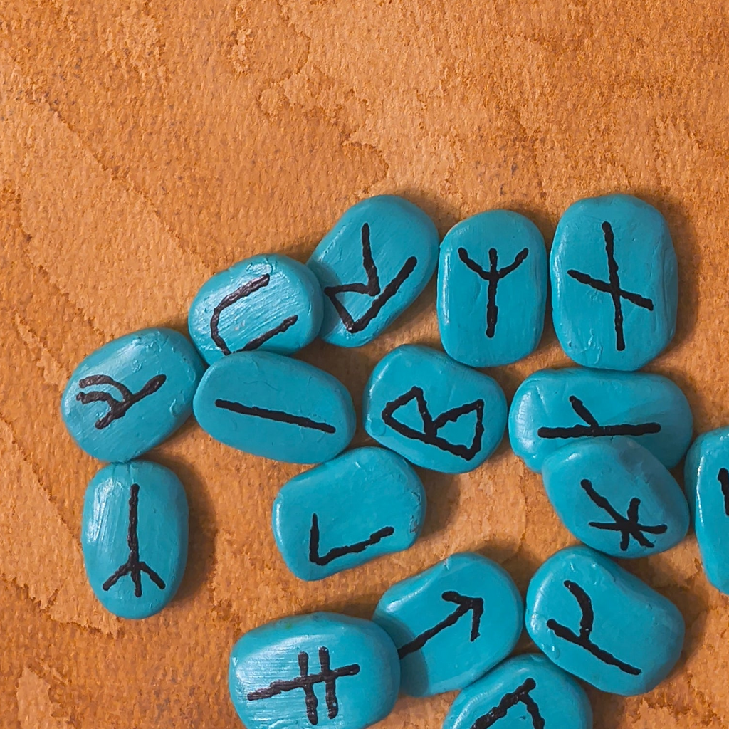 Turquoise stones with black symbols on a brown surface
