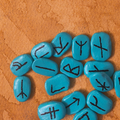 Turquoise stones with black symbols on a brown surface