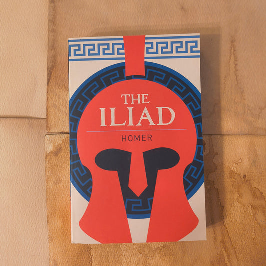 Book cover of 'The Iliad' by Homer on a brown surface